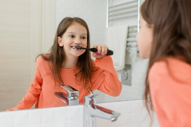 Foto menina lavando os dentes no banheiro