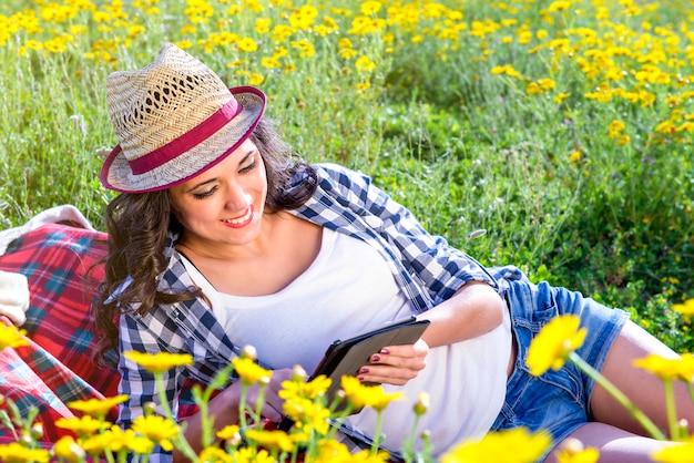 Menina lê um tablet na natureza