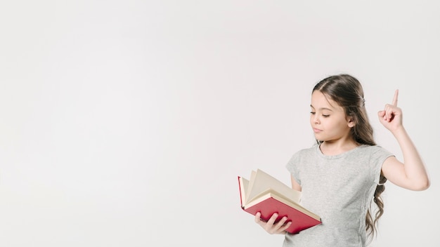 Foto menina, leitura, e, levantamento, dedo, em, estúdio