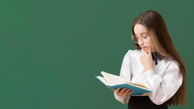 Foto menina lendo livro cópia espaço