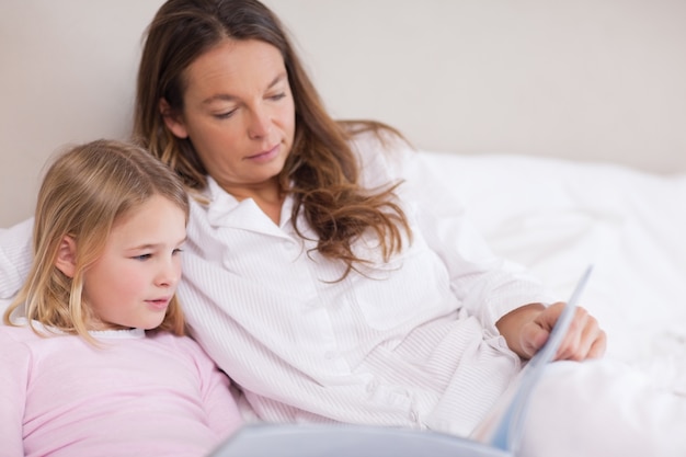 Menina lendo um livro com sua mãe