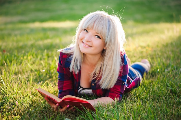 Menina lendo um livro em um parque de verão