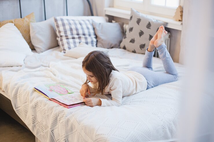 Menina lendo um livro na cama no Natal