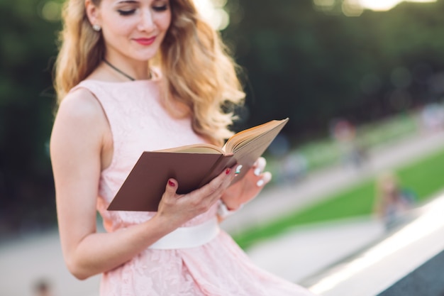 Menina lendo um livro no parque.