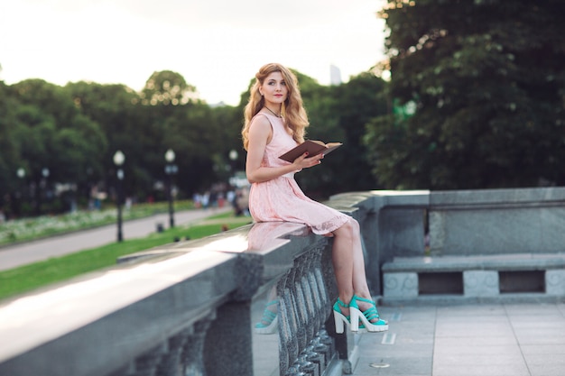 Menina lendo um livro no parque.