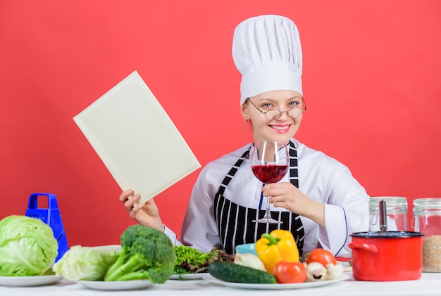 Menina leu o livro top melhores receitas culinárias Cozinha tradicional Conceito de escola de culinária Mulher de chapéu e avental sabe tudo sobre artes culinárias Especialista em culinária Mulher chef cozinhando comida saudável