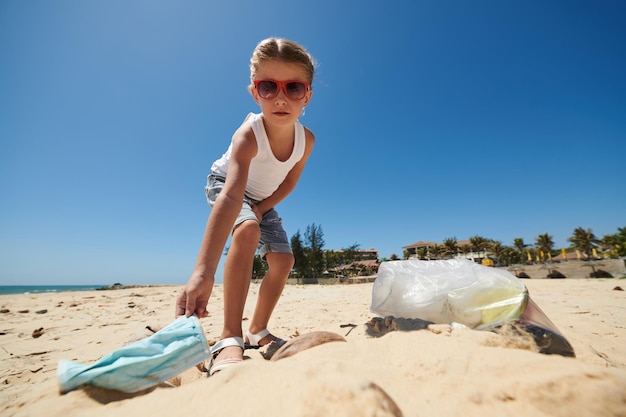 Menina limpando praia