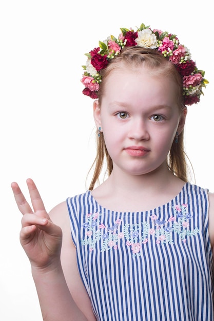 Menina linda adolescente com uma coroa de flores sobre um fundo branco