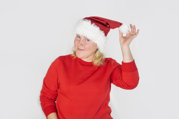 Menina linda com chapéu de Papai Noel de Natal em fundo branco isolado com cara feliz em pé e sorrindo com um sorriso confiante mostrando os dentes