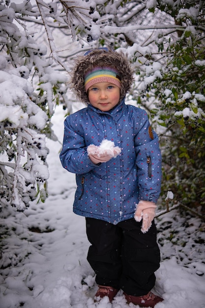 Foto menina linda com roupas de inverno sozinha no meio de uma floresta nevada