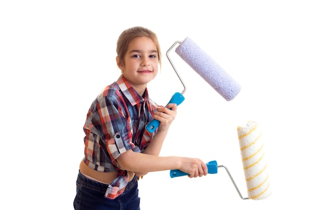 Menina linda com trança castanha longa na camisa xadrez vermelha segurando rolos coloridos no estúdio