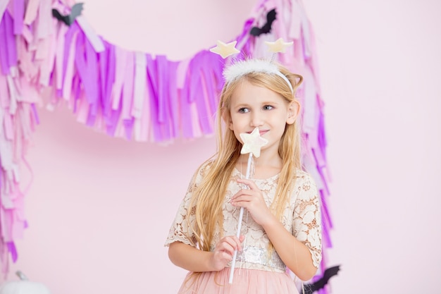 Menina linda e linda criança com fantasia de carnaval de fada e decorações da moda para o Dia das Bruxas