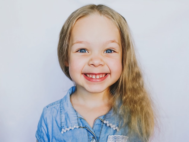 Menina linda e sorridente de olhos azuis, em um fundo branco