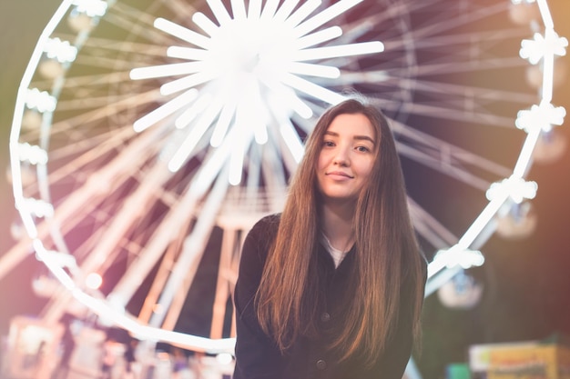 Foto menina linda em um parque de diversões em nght sorrindo roda gigante no espaço de cópia de fundo