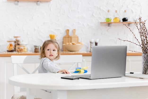 Menina linda estuda em casa durante a quarentena Criança bonita fazendo lição de casa online