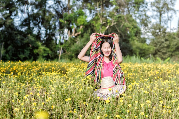 Foto menina linda jardineiro asiático em campo de flores de calêndula