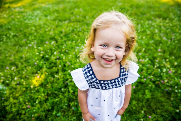 Menina linda no parque em um vestido branco