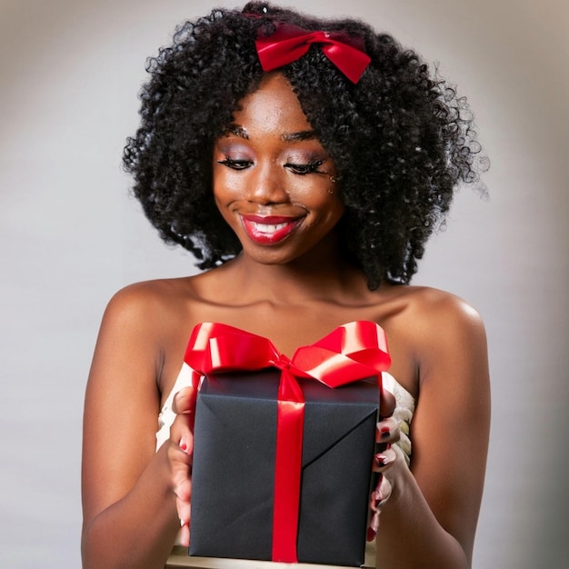 Menina linda segurando uma caixa de presente preta com uma fita vermelha