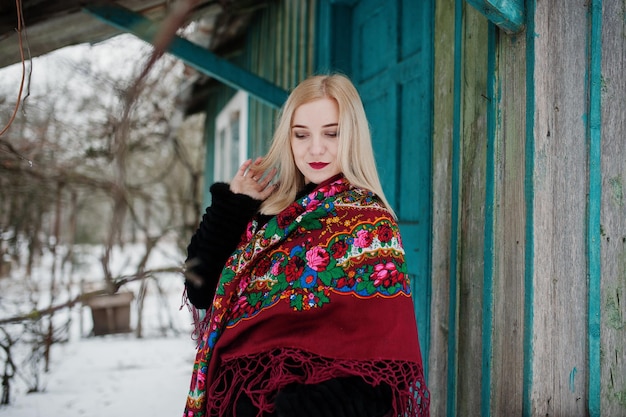 Menina loira com lenço bordado à mão posada no dia de inverno. Lenço de mulher.