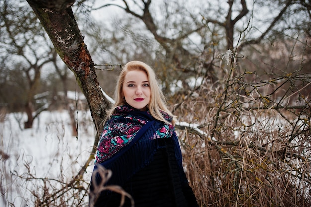 Menina loira com lenço bordado mão posou em dia de inverno.