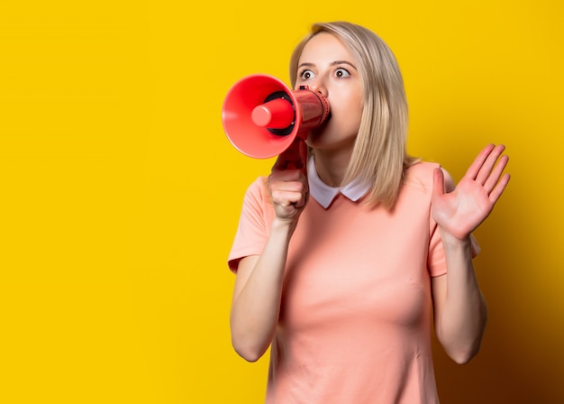 Menina loira de vestido rosa com megafone