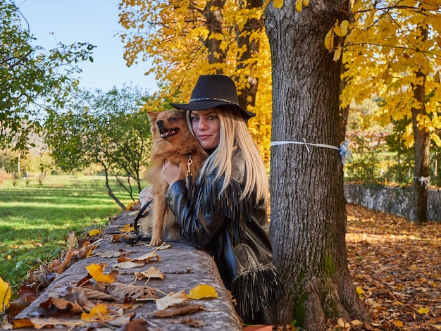 Menina loira e bonita brincando com cachorro da pomerânia