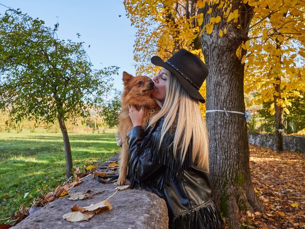 Menina loira e bonita brincando com cachorro da pomerânia