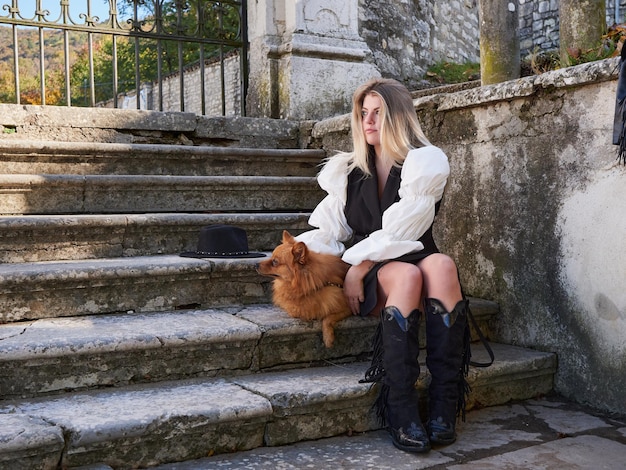 Menina loira e bonita brincando com cachorro da Pomerânia