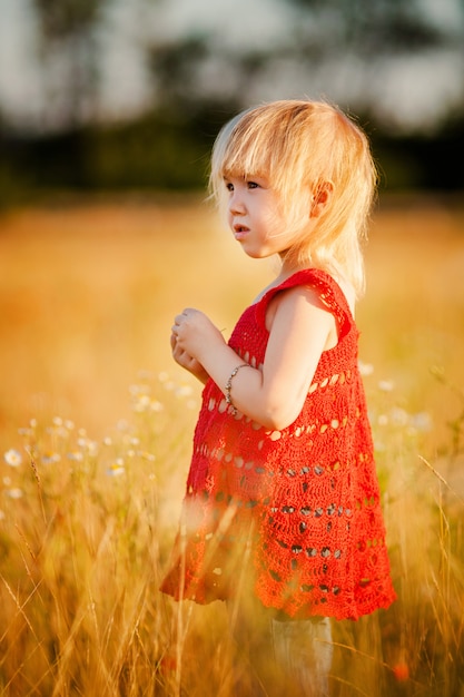 Menina loira no campo com flores