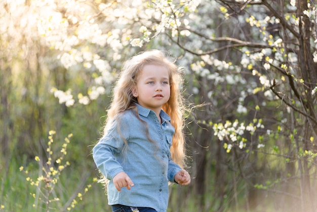 Menina loira se divertindo no parque primavera.