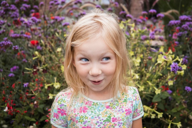 Menina loira sorridente em um fundo de flores