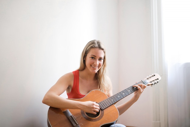 Menina loira tocando violão