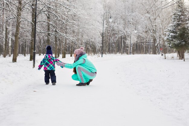 Menina mãe e filho em uma caminhada de inverno na natureza. Família feliz.