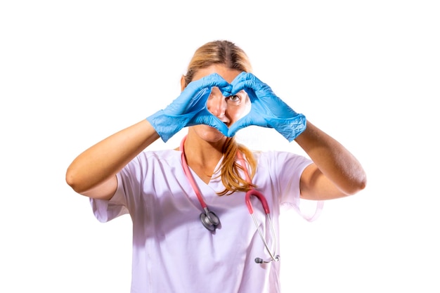 Menina médica formando um coração com as mãos em um fundo branco