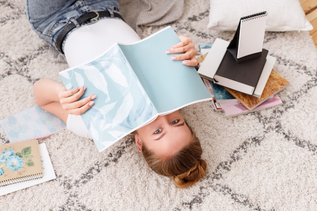 Menina mente e cobre o rosto com um caderno