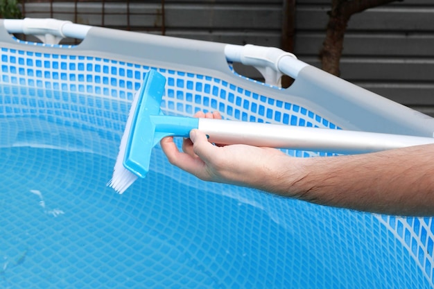 menina montando escova de piscina limpando piscina com uma escova especial