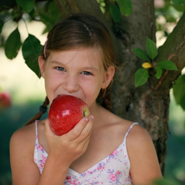 Menina mordendo uma maçã
