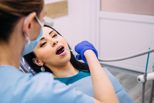 Menina morena atraente na consulta do dentista