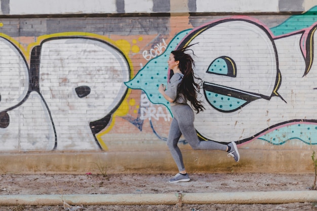 Menina morena correndo na rua