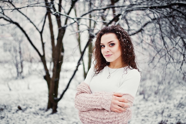 Menina morena encaracolada na paisagem de neve