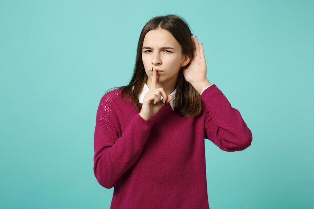 Foto menina morena jovem em roupas casuais posando isolado no retrato de estúdio de fundo de parede azul verde turquesa. conceito de estilo de vida de emoções sinceras de pessoas. mock up espaço de cópia. tente te ouvir.