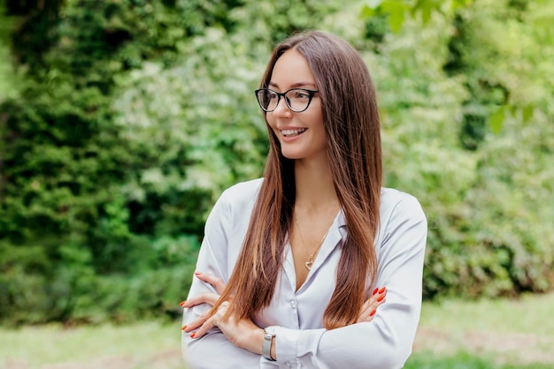 Menina morena sorridente em óculos no contexto do espaço de cópia da natureza