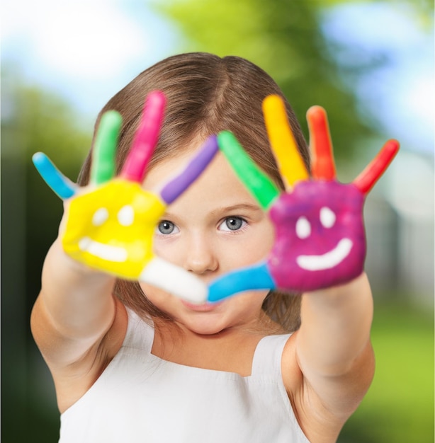 Menina mostrando as mãos pintadas no fundo brilhante