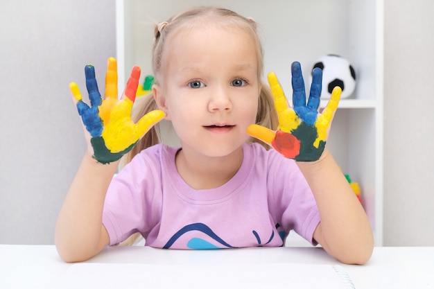 Menina mostrando as mãos pintadas