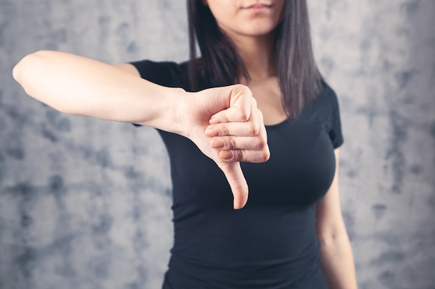 Menina mostrando mau sinal, polegar para baixo