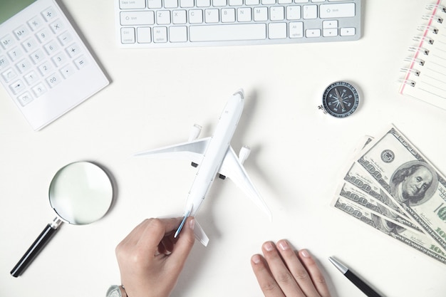 Menina mostrando o avião na mesa. viajar por