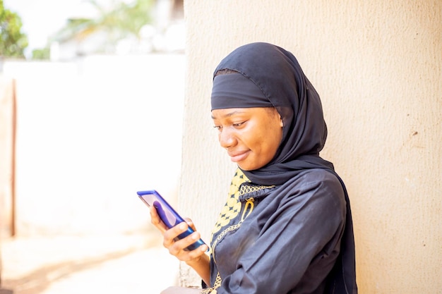 menina muçulmana com hijab usando smartphone