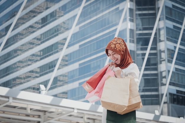 Menina muçulmana com sacola de compras