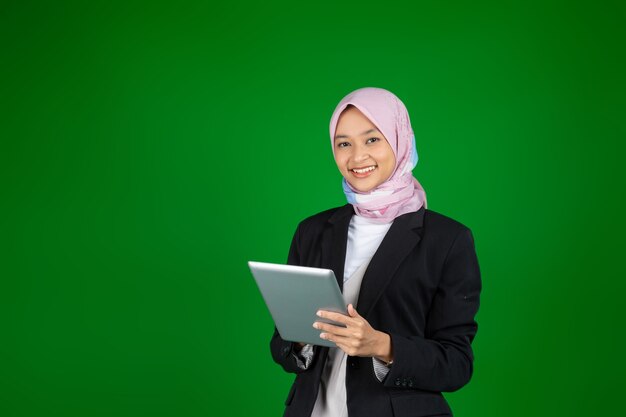 Menina muçulmana em hijab usando um tablet digital com copyspace