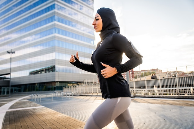 Menina muçulmana esportiva com exercícios físicos ao ar livre